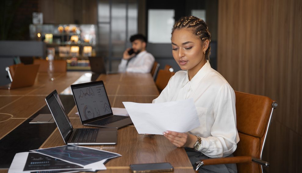 A research analyst reviewing charts and data across two laptops