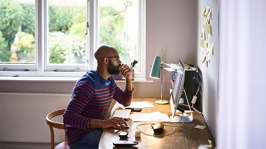 A contractor working from a well-equipped home office desk